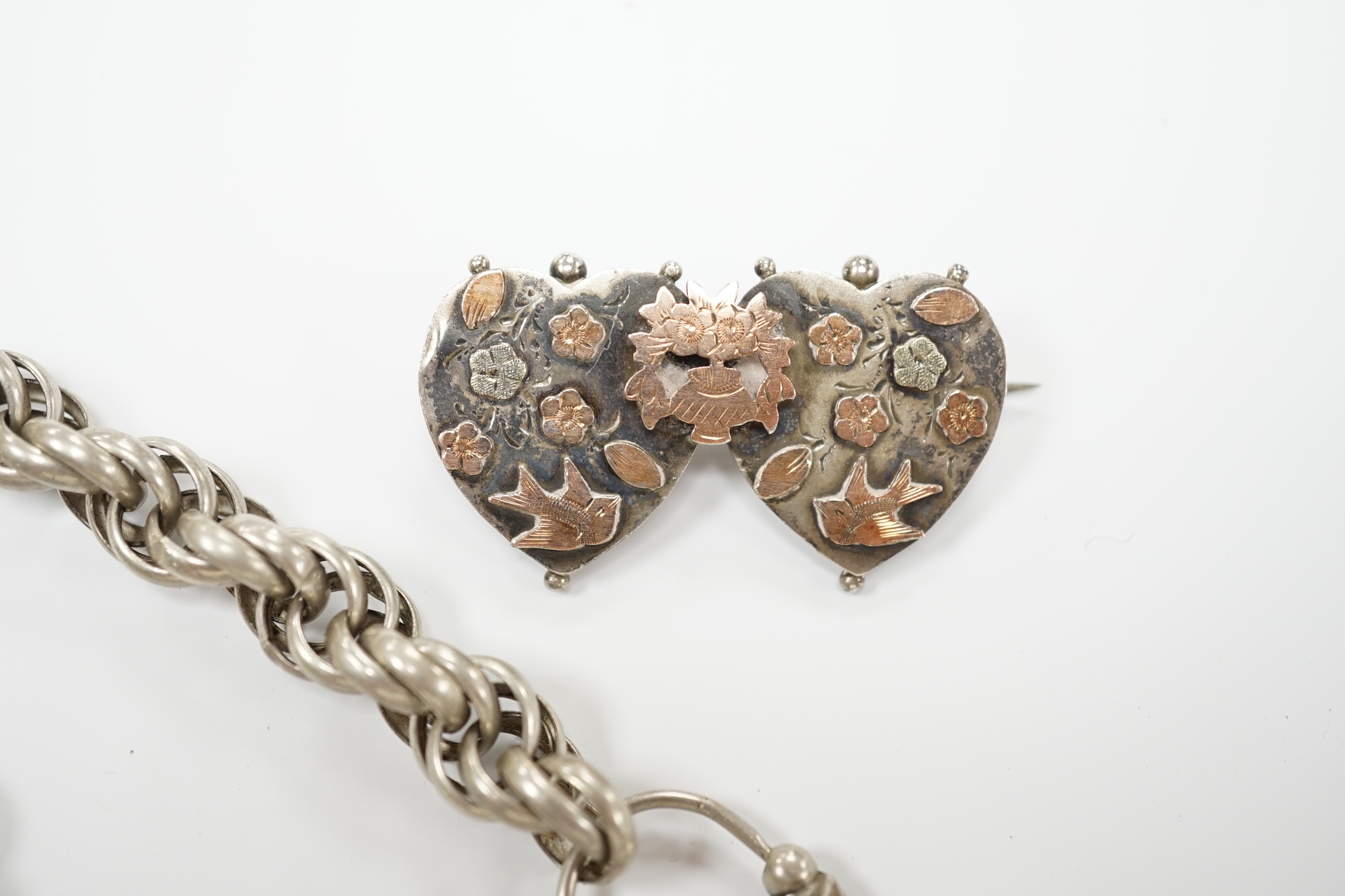 A Victorian white metal chains with a locket, a white metal bracelet and a sterling double heart shaped brooch.